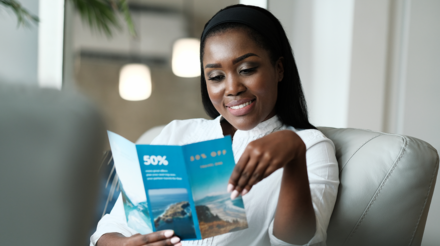 A person reading a printed personalized travel brochure